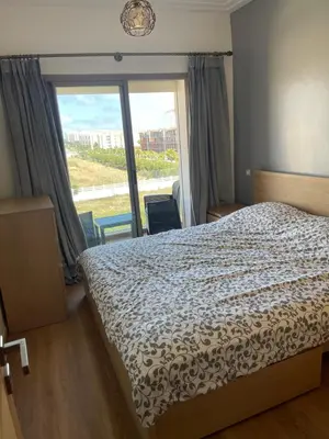 a bedroom with a bed and a large window at Superbe Appt avec grande piscine 2 in Dar Bouazza