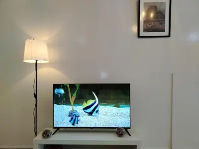 a flat screen tv sitting on a table next to a lamp at Appartement Casa Voyageurs in Casablanca
