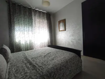 a bedroom with a bed next to a window at rabatapartmentresidence in Rabat