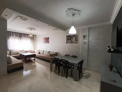 a living room with a table and a couch at rabatapartmentresidence in Rabat