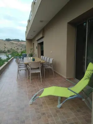 a patio with a table and chairs on a balcony at Lake House Boulaouane in El Jadida