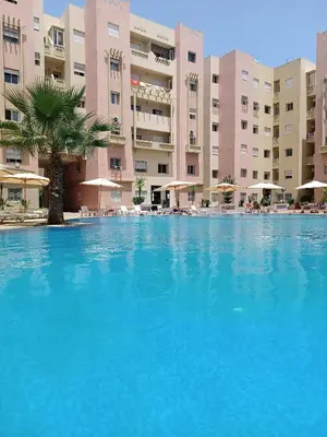 a large swimming pool in front of a building at Appartement avec piscine à Mohammedia Plage à 5min in Mohammedia