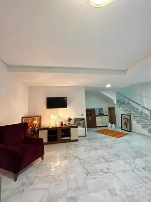 a large living room with a couch and a tv at Magnifique duplex moderne à 1 minute à pied de la plage- Résidence Miramar Mohammedia in Mohammedia