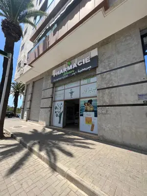 a building with a palm tree in front of it at Magnifique duplex moderne à 1 minute à pied de la plage- Résidence Miramar Mohammedia in Mohammedia