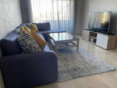 a living room with a blue couch and a coffee table at Cosy Apartment with sea view in Sidi Rahal