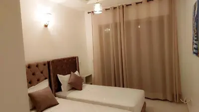 a small bedroom with two beds and a window at Appartement Costa Bouznika in Bouznika