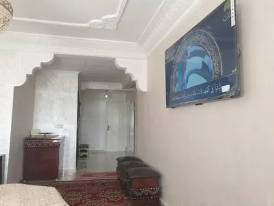 a room with a wall with a tv on the wall at Appartement Meublé AIN SEBAA in Aïn Sebaa