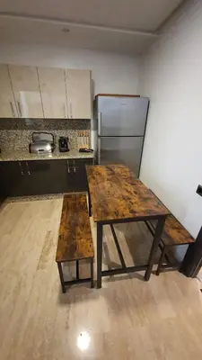a kitchen with a wooden table and a refrigerator at Casa Fainna in Casablanca