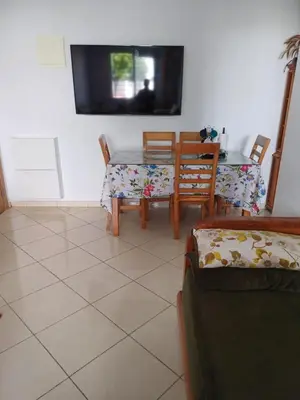 a dining room with a table and chairs and a tv at Super et nouvel appart proche de la plage in Temara