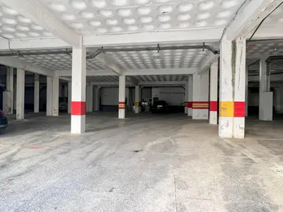 an empty parking garage with white columns and red stripes at Grand Appartement Vue mer à Ain Diab - Calme Absolu in Casablanca