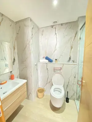 a bathroom with a white toilet and a sink at Appartement en bord de mer in Pont Blondin