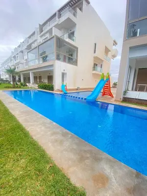 a swimming pool with a slide in front of a building at Appartement en bord de mer in Pont Blondin
