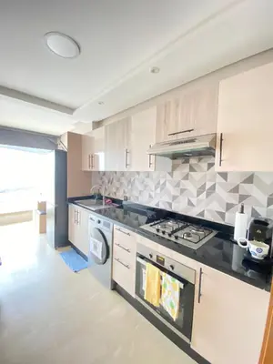 a kitchen with a stove and a washer and dryer at Appartement en bord de mer in Pont Blondin