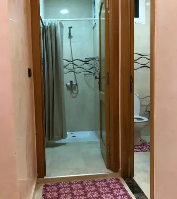 a bathroom with a shower and a glass door at Luxurious Holiday Home in Temara