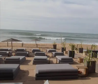 a row of chaise lounges on a beach with the ocean at Hébergement bord de mer in Casablanca