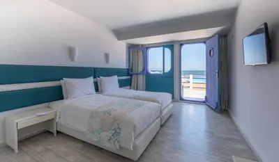 a bedroom with a large bed with a view of the ocean at Hotel Tropicana in Casablanca