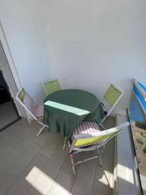 a room with a table and chairs on a balcony at Eden tamaris résidence in Dar Bouazza