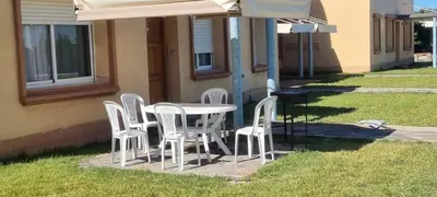 a table with white chairs and an umbrella at Ferme d'hôte Evasio in Sidi Rahal