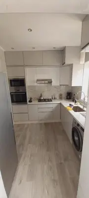 a kitchen with white cabinets and a washer at Residence Al Kawtar in Mohammedia