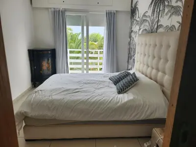 a bedroom with a large bed with a window at Appartement Luxueux vue Mer dans Résidence avec piscines et jardin in Dar Bouazza