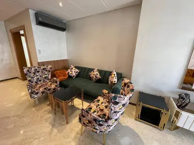 a living room with a green couch and chairs at Appartement de luxe à peninsula in Casablanca
