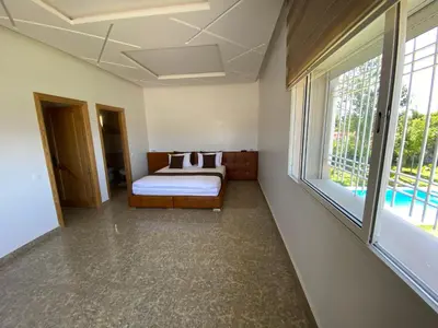 a bedroom with a bed and a large window at Villa in Rabat in Oulad Mbark