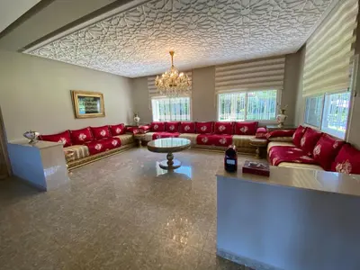 a large living room with red couches and a chandelier at Villa in Rabat in Oulad Mbark
