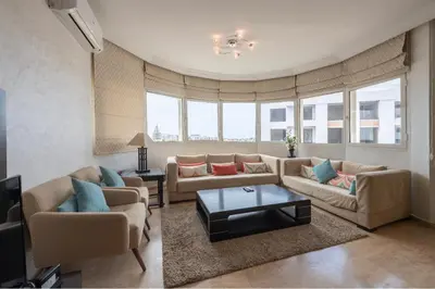 a living room with two couches and a table at Cosy Apartment 200 M2 Hay Ryad Rabat in Rabat