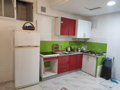 a kitchen with red and green cabinets and a refrigerator at Sotto ma carino in Temara