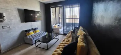 a living room with a couch and chairs and a tv at La terrasse d'Audrey - Short stay au coeur du Maarif in Casablanca