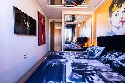a room with a bed with blue sheets and a couch at La terrasse d'Audrey - Short stay au coeur du Maarif in Casablanca