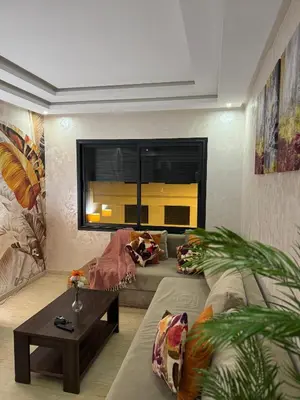 a living room with a couch and a table at App à côté du parc et corniche in Mohammedia