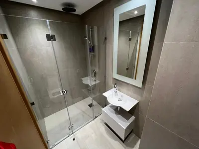 a bathroom with a glass shower and a sink at Appartement Ocean View - Marina Casablanca in Casablanca