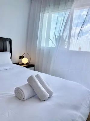 a white bed with two towels on it with a window at Appartement au cœur de Rabat in Rabat