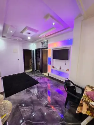a living room with purple lighting and a tv at chez Jalil in Aïn ej Jmel