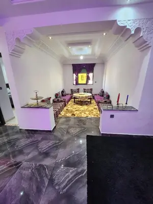 a large living room with purple walls and a marble floor at chez Jalil in Aïn ej Jmel