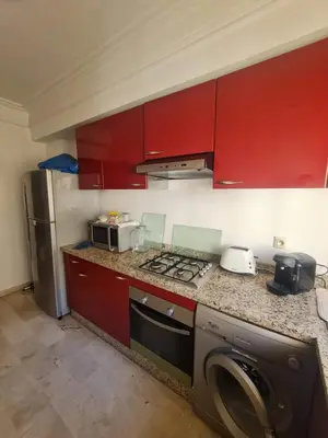a kitchen with red cabinets and a washing machine at Horizon Appartement Playa in Casablanca