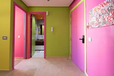 a hallway with pink doors and green walls at Pop Art Studio-Location Journalière Casablanca in Casablanca