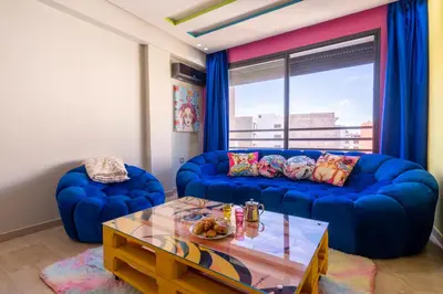 a living room with a blue couch and a table at Pop Art Studio-Location Journalière Casablanca in Casablanca