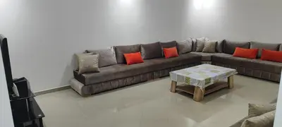 a living room with a couch and a table at APPARTEMENT haut standing in O Ben Slimane
