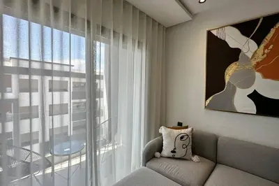 a living room with a couch and a large window at Top Floor Studio - By AppartAli in Casablanca