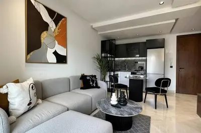 a living room with a couch and a table and a kitchen at Top Floor Studio - By AppartAli in Casablanca