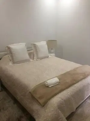 a bed with a blanket and pillows on it at Appartement Casablanca in Dar Bouazza