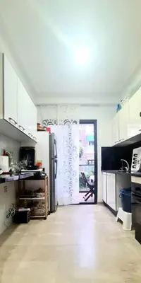 a kitchen with a refrigerator and a door to a patio at Appartement Casablanca in Dar Bouazza