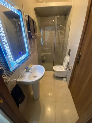 a bathroom with a sink and a toilet and a mirror at Appartement avec suite parentale in Mohammedia