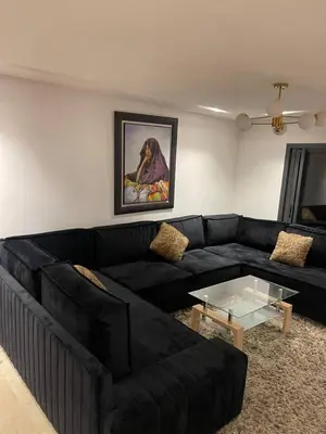 a living room with a black couch and a glass table at La perle corniche in Casablanca