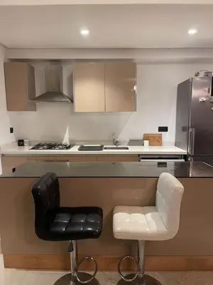 a kitchen with a black and white chair and a counter at La perle corniche in Casablanca