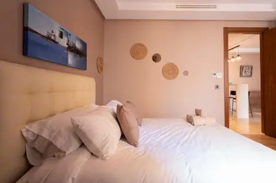 a bedroom with a white bed with a television on the wall at Suite Apt Bourgogne N°2, 2 P in Casablanca