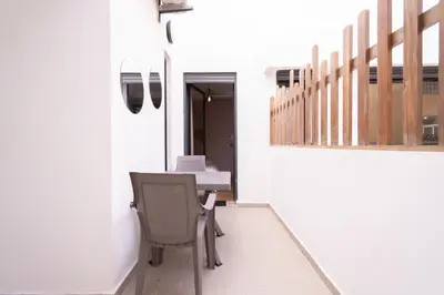 a room with a table and chairs and a staircase at Suite Apt Bourgogne N°2, 2 P in Casablanca