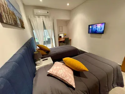 a living room with two beds and a tv at Au Cœur Des Sables D’or - Harhoura in Temara